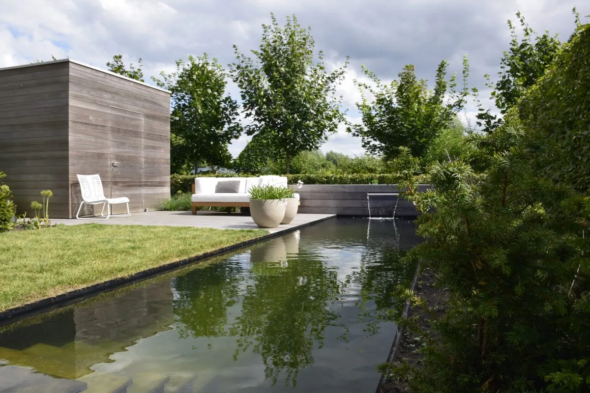Vakkundig aangelegde tuin met groene borders en terras