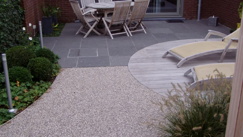 Verzorgde tuin in herfstsfeer met gevallen blad langs een gesnoeide border